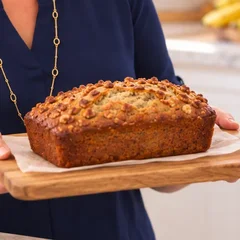 A loaf of banana bread topped with toasted nuts